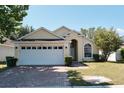 House exterior, featuring a two-car garage and landscaped lawn at 2726 Randal Way, Kissimmee, FL 34743