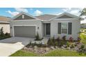 One-story home with gray exterior, landscaping, and two-car garage at 2204 Mac Blvd, Eagle Lake, FL 33839