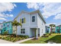 Two-story light blue house with yellow accents, palm tree, and landscaping at 3184 Caribbean Soul Dr, Kissimmee, FL 34747