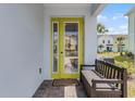 Front porch with a yellow door, a dark brown bench, and a small rug at 3184 Caribbean Soul Dr, Kissimmee, FL 34747