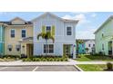 Two-story light blue house with yellow accents, palm tree, and landscaping at 3184 Caribbean Soul Dr, Kissimmee, FL 34747