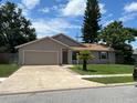 Tan one-story house with a two-car garage and landscaping at 866 Crows Bluff Ln, Sanford, FL 32773