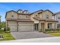 Tan two-story house, three-car garage, and a landscaped yard at 7650 Wandering Way, Orlando, FL 32836