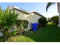Side of house with landscaping, trash cans, and AC unit at 2221 The Oaks Blvd, Kissimmee, FL 34746