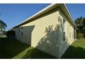 Side view of yellow house with windows and landscaping at 2221 The Oaks Blvd, Kissimmee, FL 34746