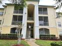 Condo building exterior showcasing balconies and landscaping at 8826 Dunes Ct # 207, Kissimmee, FL 34747