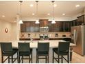 Modern kitchen with dark cabinets, granite island, and stainless steel appliances at 2022 Majorca Dr, Kissimmee, FL 34747