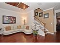 Living Room with hardwood floors, white sectional sofa, and stairs at 1126 Tapestry Dr, Celebration, FL 34747