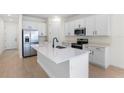 Modern kitchen with white cabinets, quartz countertops, and stainless steel appliances at 2303 Jagger Ln, Eagle Lake, FL 33839