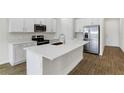 Modern kitchen with white cabinets, stainless steel appliances, and an island at 151 Bull Frog Ln, Umatilla, FL 32784