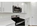 Modern kitchen with stainless steel appliances and white cabinets at 151 Bull Frog Ln, Umatilla, FL 32784