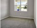 Bright bedroom with gray walls, gray carpet, and a large window at 155 Bull Frog Ln, Umatilla, FL 32784