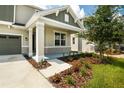 Two-story house with gray siding, stone accents, and a covered porch at 155 Bull Frog Ln, Umatilla, FL 32784