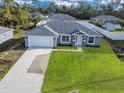 Newly constructed home with gray exterior, white garage door, and landscaped lawn at 16619 Sw 31St Cir, Ocala, FL 34473