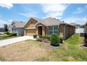 Tan one-story house with a two-car garage and a small front yard at 1843 Brockridge Rd, Kissimmee, FL 34744