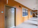 Building hallway with a tan wall and a brown door at 12539 Floridays Resort Dr # 305-D, Orlando, FL 32821