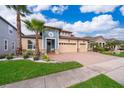 Two-story house with a three-car garage, palm trees, and well-maintained landscaping at 2518 Fontaine Dr, Kissimmee, FL 34741