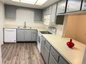 Bright kitchen with gray cabinets, white appliances, and vinyl flooring at 414 Banana Cay Dr # I, South Daytona, FL 32119