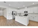 Modern kitchen with white cabinets, island, and stainless steel appliances at 154 Bull Frog Ln, Umatilla, FL 32784
