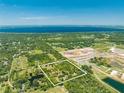 Aerial view of a lot with lush vegetation, a pond, and nearby lake at 1235 Hackney Rd, St Cloud, FL 34771