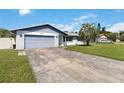 Brick ranch house with a gray garage door and a long driveway at 7414 Betty St, Winter Park, FL 32792