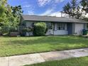 Gray house with a spacious yard and mature landscaping at 101 Albert St, Winter Springs, FL 32708