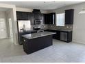 Open kitchen features dark cabinetry, granite countertops, and stainless steel appliances at 2757 Creekmore Ct, Kissimmee, FL 34746