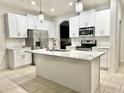 Modern kitchen with white cabinets, island, and stainless steel appliances at 2391 Beacon Park Landing Cir, Orlando, FL 32824
