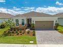 Single-story home with a two-car garage and landscaped front yard at 2012 Spring Shower Cir, Kissimmee, FL 34744