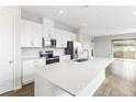 Modern kitchen featuring white cabinets, stainless steel appliances, and a large island at 6357 Clover St, Lake Hamilton, FL 33851