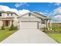 Front view of charming house with a two-car garage and landscaped yard at 6357 Clover St, Lake Hamilton, FL 33851