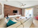 Spacious living room featuring a large sectional sofa and wood-look feature wall at 2955 Beach Palm Ave, Kissimmee, FL 34747