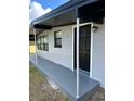 Front entrance of the home with a black door and gray concrete walkway at 1541 N Hudson St, Orlando, FL 32808