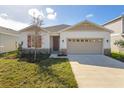 Newly built house with beige exterior, two-car garage, and red shutters at 171 Bull Frog Ln, Umatilla, FL 32784