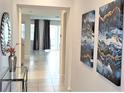 Bright and airy entryway with tile flooring, a glass-top console table, and modern wall art at 1754 Caribbean View Ter, Kissimmee, FL 34747