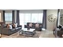 Spacious living room with gray leather sofas, a large TV, and access to the pool area at 1754 Caribbean View Ter, Kissimmee, FL 34747