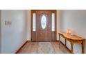 Entryway with wood door, tile floor, and console table at 4450 Kaiser Ave, St Cloud, FL 34772