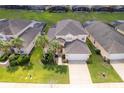 Aerial view of a house with a two-car garage and lush lawn at 8612 La Isla Dr, Kissimmee, FL 34747