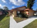 Tan one-story house with a walkway to the front door and garage at 3180 Owassa Ct, Kissimmee, FL 34746
