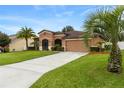 One-story house with a two-car garage and palm trees at 840 Crooked Branch Dr, Clermont, FL 34711