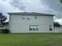Rear view of a two-story house with gray siding and grassy lawn at 2480 Hassonite St, Kissimmee, FL 34744