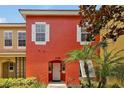 Orange townhome with white shutters and door at 2758 Sun Key Pl, Kissimmee, FL 34747