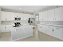 Modern kitchen featuring white cabinets, stainless steel appliances, and a large island at 180 Flag Lilly Ln, Umatilla, FL 32784