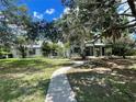 Two-story home with mature trees, a walkway, and ample yard space at 2086 Camelot Blvd, St Cloud, FL 34772
