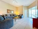 Bright living room with comfy seating, tile floors, and access to a patio at 648 Copeland Dr, Haines City, FL 33844