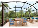 Relaxing screened patio with wooden furniture, ideal for outdoor dining and lounging at 709 Carmel Ln, Kissimmee, FL 34759