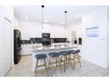 Modern kitchen with white cabinets, stainless steel appliances, and an island at 3028 Protagonist St, Kissimmee, FL 34746