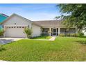 One-story house with attached garage and a well-maintained lawn at 2419 Willow Tree Ln, Kissimmee, FL 34758