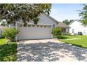 Attached garage with a double door and a concrete driveway at 2419 Willow Tree Ln, Kissimmee, FL 34758