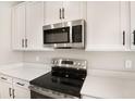 Stainless steel appliances and white cabinetry in a modern kitchen at 4252 Sawtooth Ct, Tavares, FL 32778